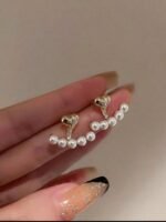 ⁦زوج من الأقراط النسائية بتصميم قلب لطيف مزين باللؤلؤ، يتميز بالأناقة وسهولة التنسيق مع مختلف الإطلالات. إكسسوار مثالي للارتداء اليومي، كما يُعد هدية رائعة للسيدات في المناسبات، وأعياد الميلاد، وغيرها من الاحتفالات.⁩ - الصورة ⁦2⁩